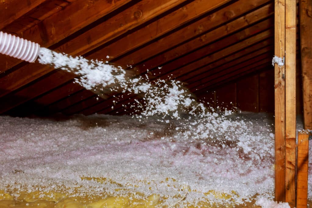 fiberglass insulation being blown into an attic by Attis Insulation in Wayne County PA